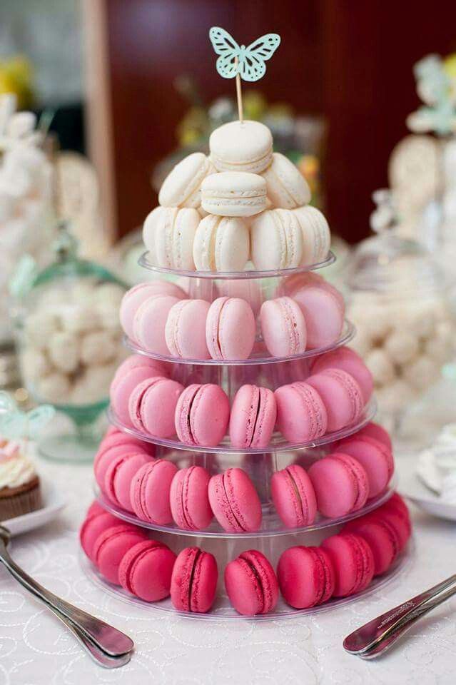 a stack of pink and white macaroons with a butterfly on top