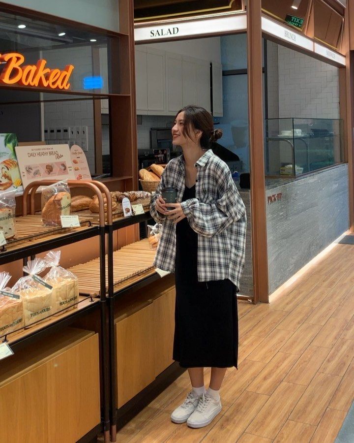 a woman standing in front of a bakery counter