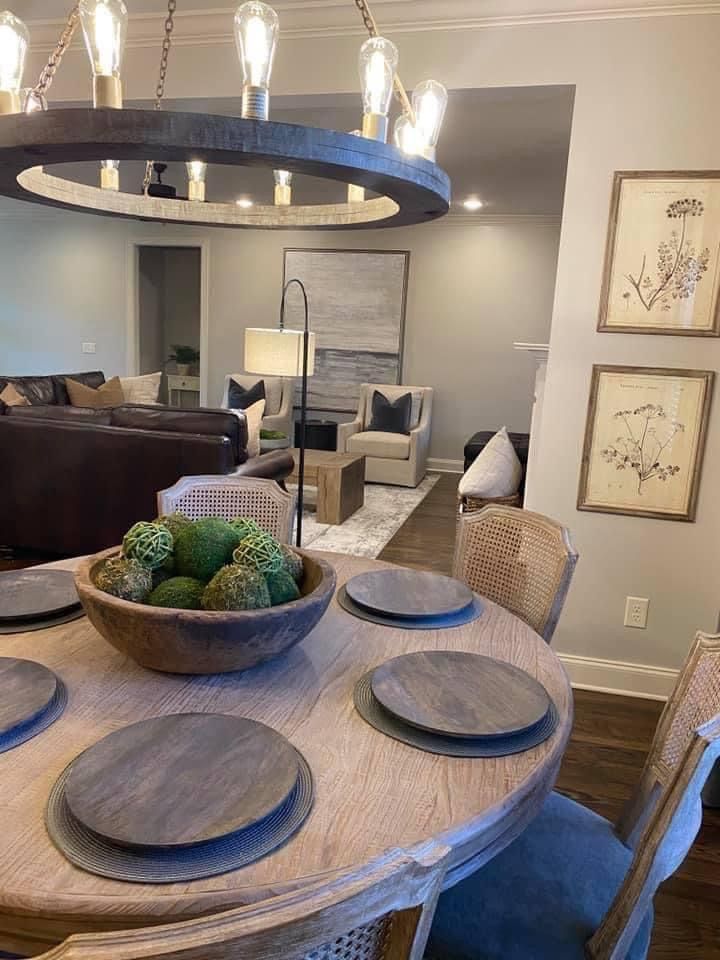 a dining room table with plates and bowls on it in front of a living room