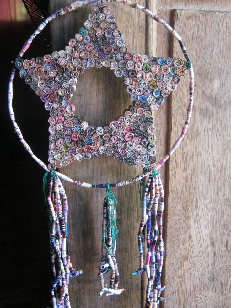 a star shaped decoration made out of buttons and other items hanging on a wooden door