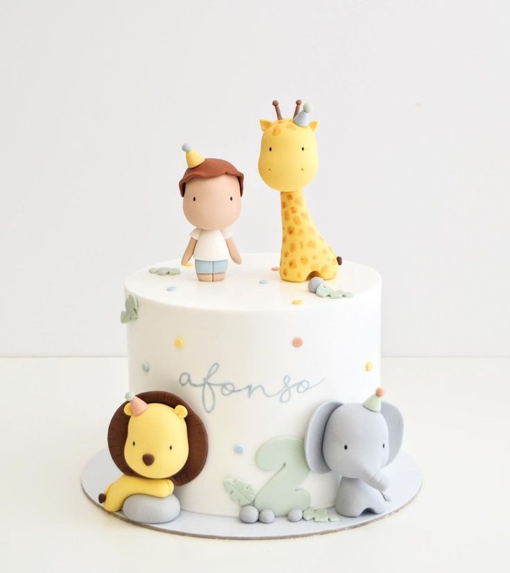 a white cake topped with animals and giraffes