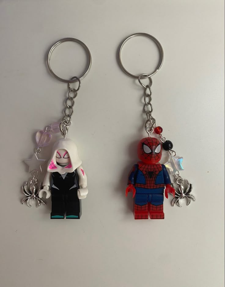 two lego key chains with spider - man and cat on them