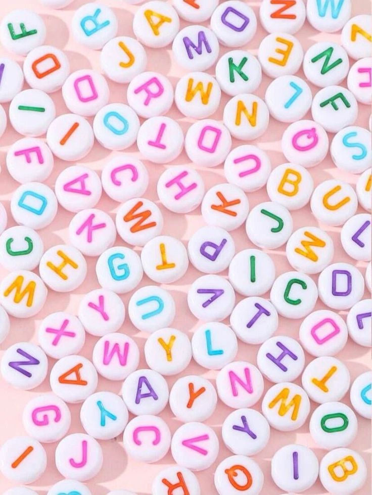 colorful letters and numbers are scattered on a pink surface