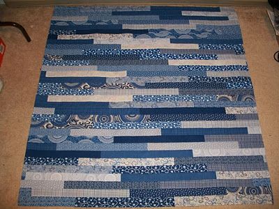 a blue and white quilt is laying on the floor