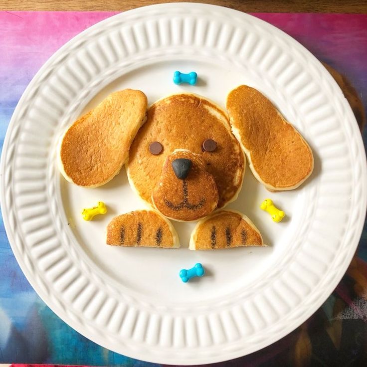 a white plate topped with pancakes shaped like a dog