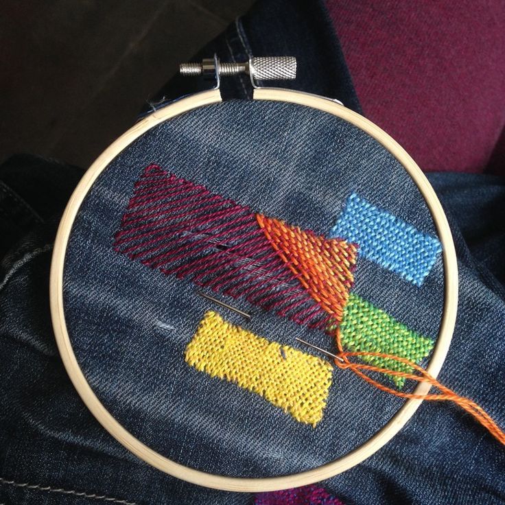 a close up of a person's jeans with a cross stitch pattern