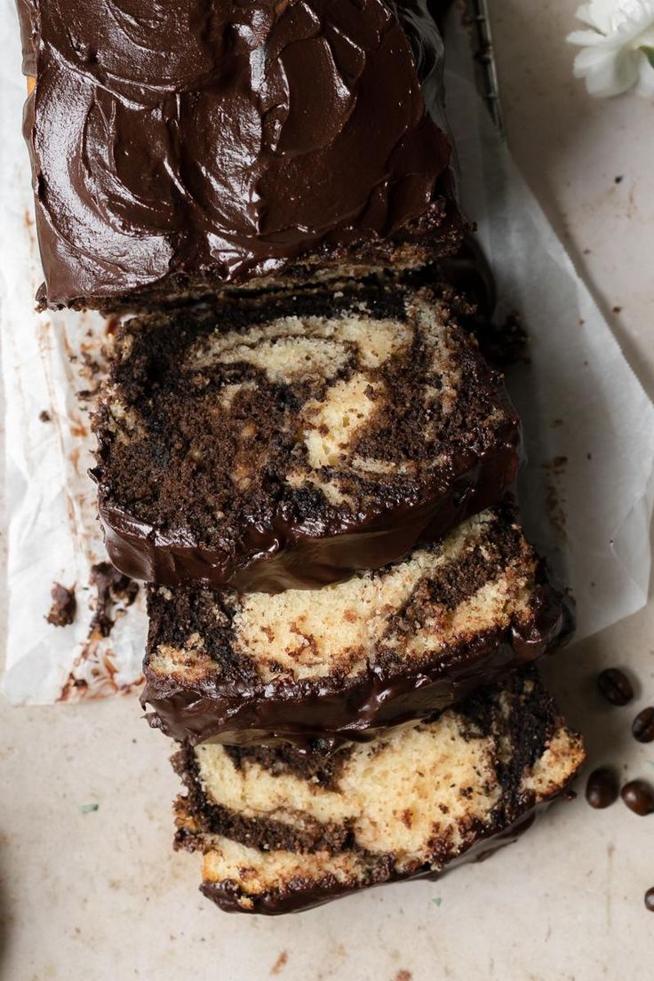 slices of chocolate marbled cake sitting on top of each other next to coffee beans