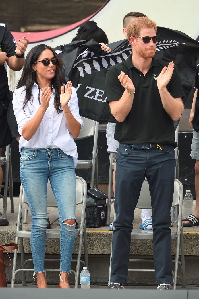 prince harry and the duke of cambridge applauding on stage at an outdoor event