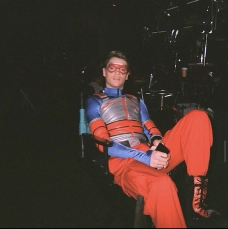 a man sitting in a chair with red pants