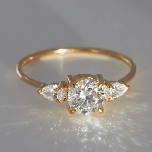 three stone diamond ring in yellow gold with diamonds on the sides and four smaller stones at the top