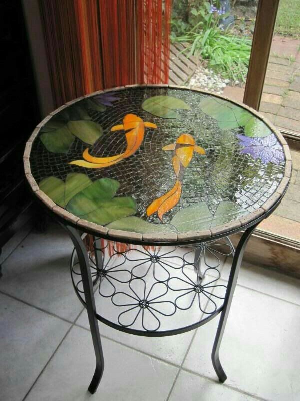 a glass table with goldfishs on it in front of a sliding glass door