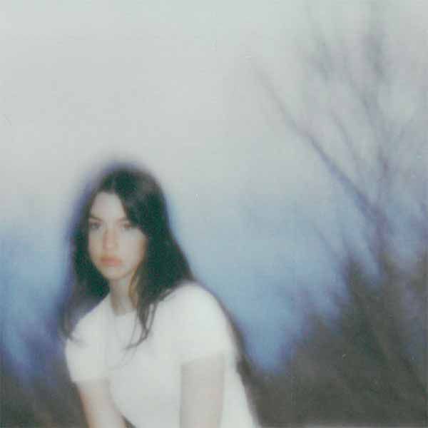 a woman in white shirt sitting on top of a skateboard