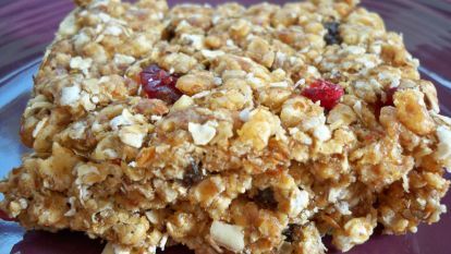 a purple plate topped with oatmeal and cranberry granola bars