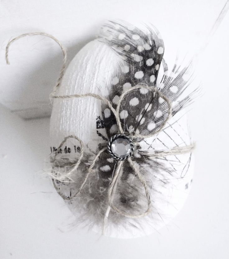 a white object with black and white feathers on it's side, next to a ball of twine