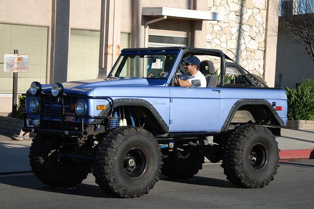 a man driving a blue truck down the street