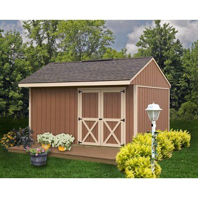 a garden shed is shown with flowers and plants in the front yard, along with a lamp post