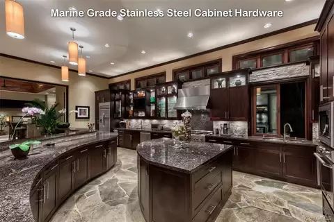 a large kitchen with granite counter tops and dark wood cabinets, along with marble flooring