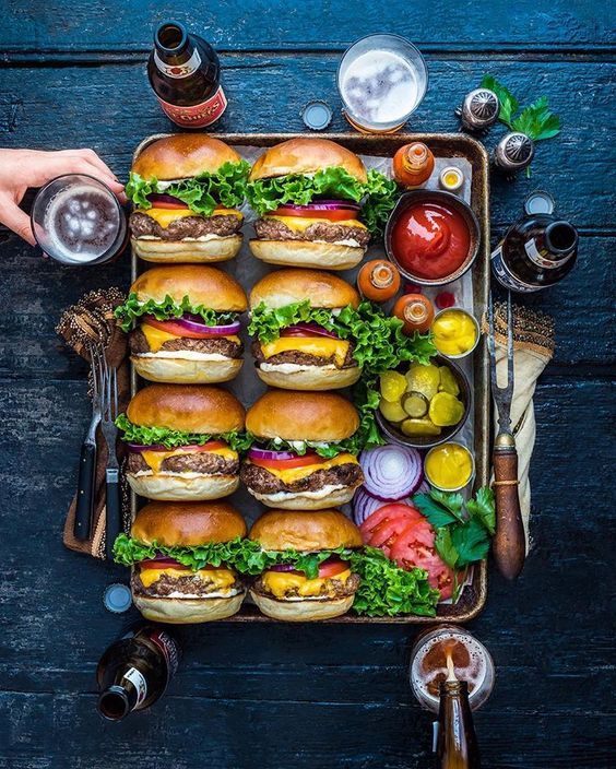 a tray filled with lots of hamburgers on top of a table