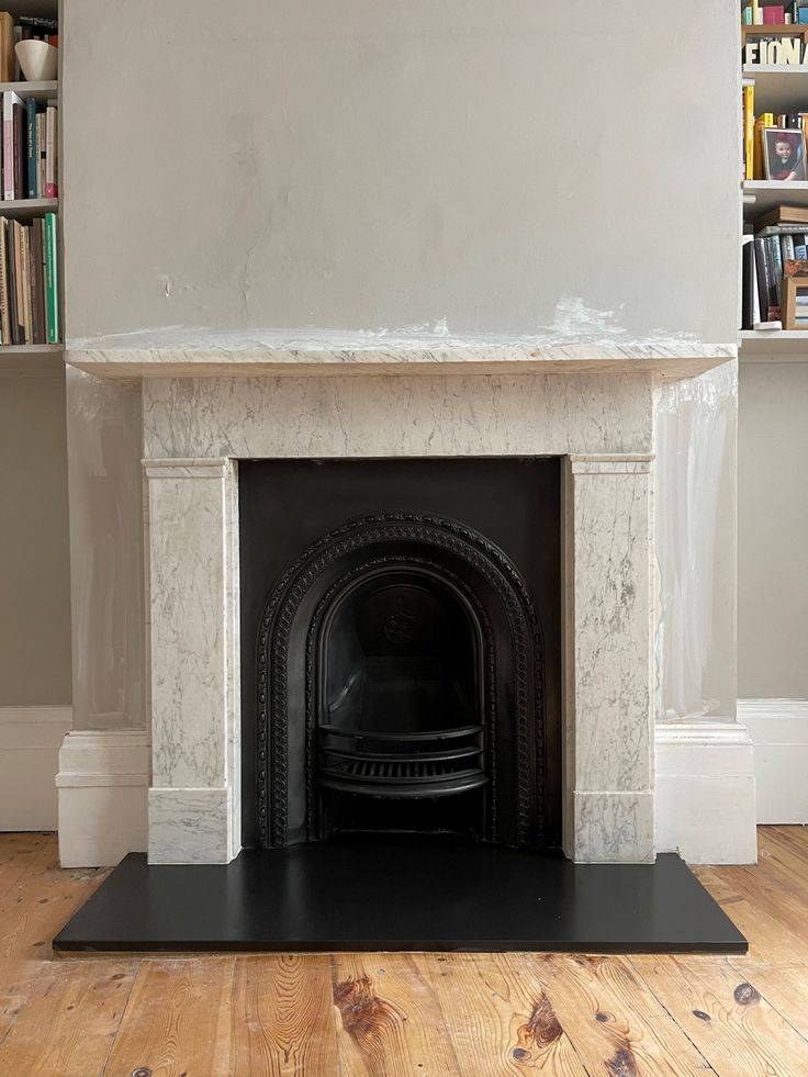 a fireplace with a bookcase in the background