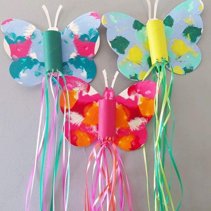 paper plate butterfly craft with streamers attached to it's wings on a wall