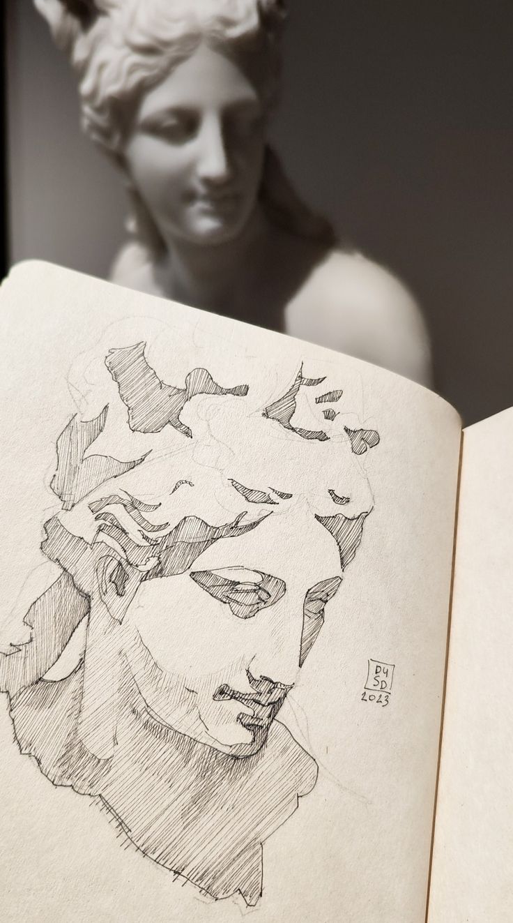 an open book with a drawing of a woman's head on top of it