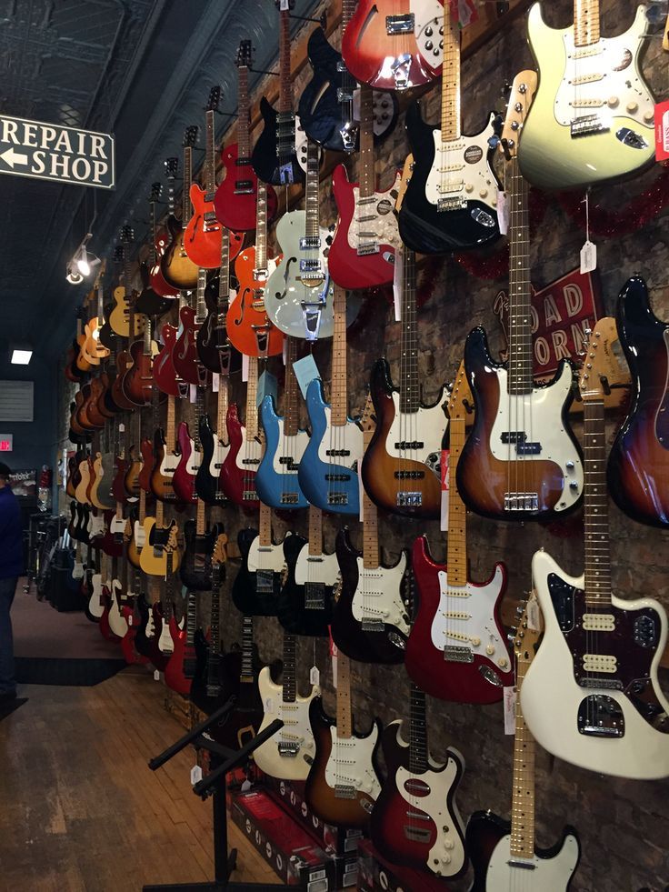 guitars are hanging on the wall in a music store