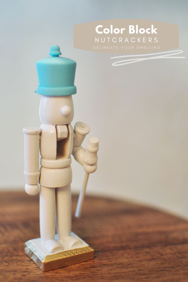 a toy soldier holding a paintbrush on top of a wooden table