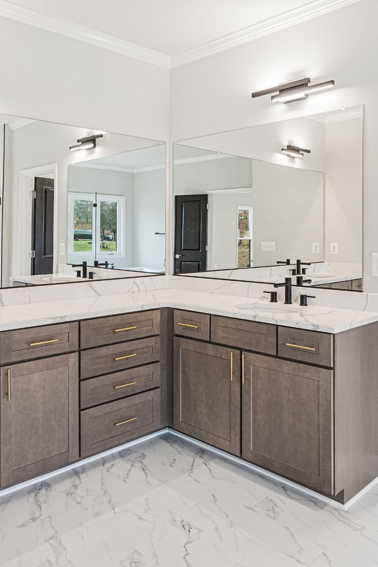 a large bathroom with two sinks and mirrors