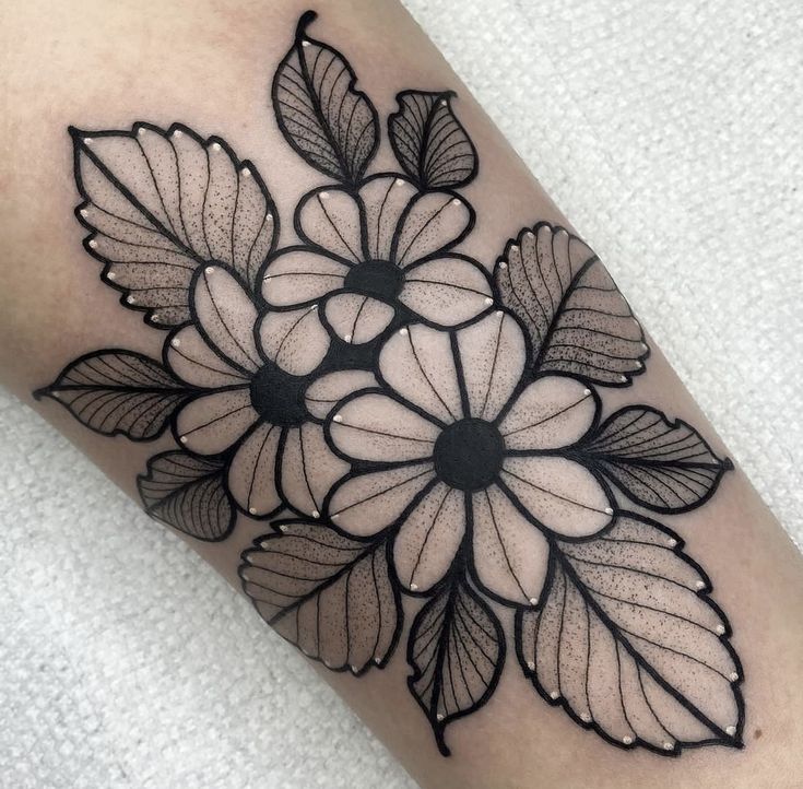 a black and white flower tattoo on the arm