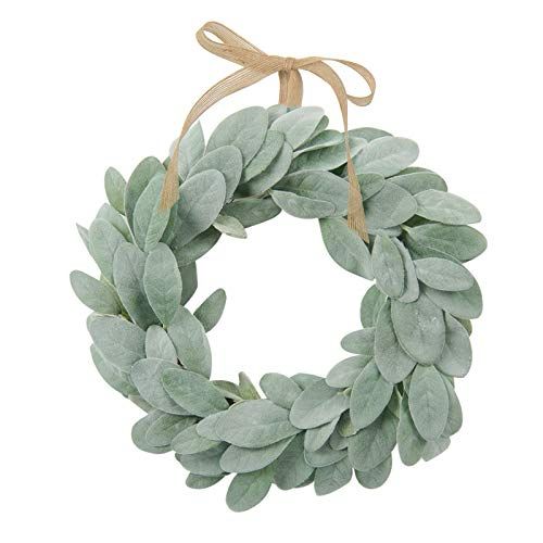 a wreath with green leaves hanging on a rope