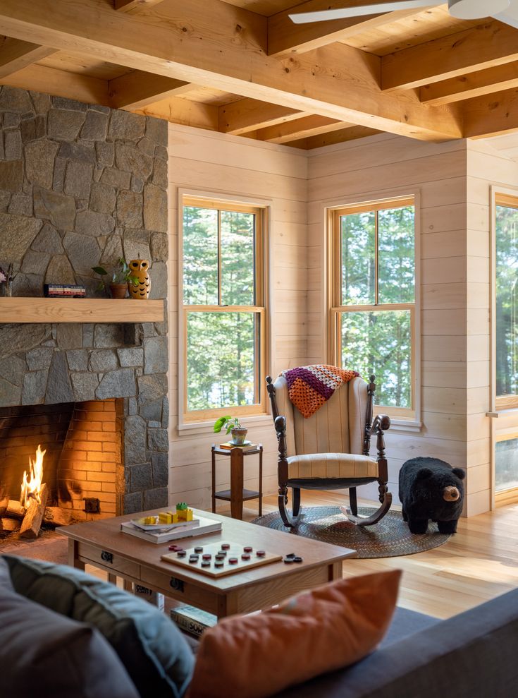 a living room filled with furniture and a fire place in front of a stone fireplace