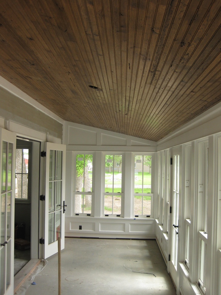 an empty room with white walls and wood ceilinging is shown in the foreground