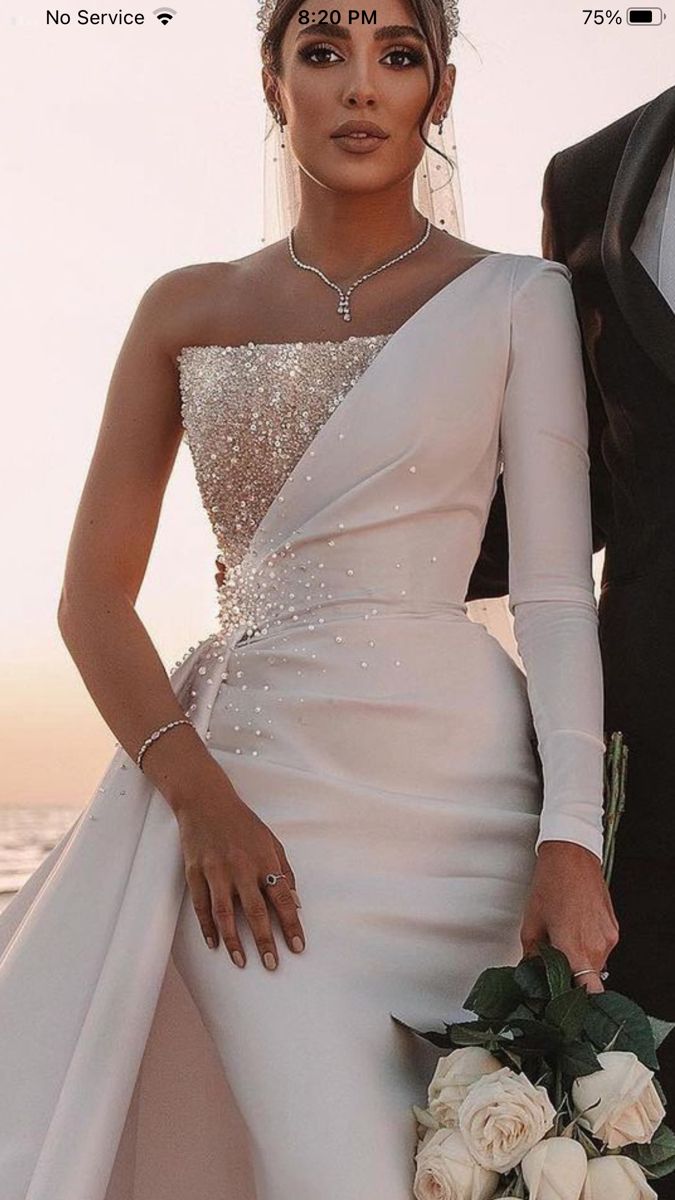 a woman in a wedding dress standing next to a man wearing a tuxedo