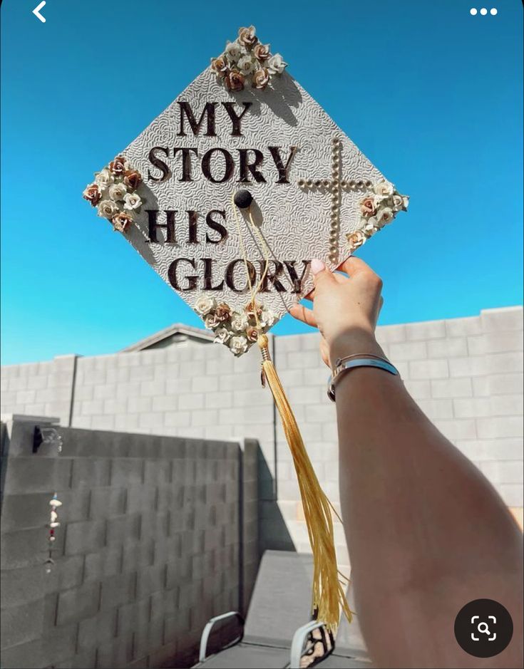 someone holding up a graduation cap that says, my story his glory