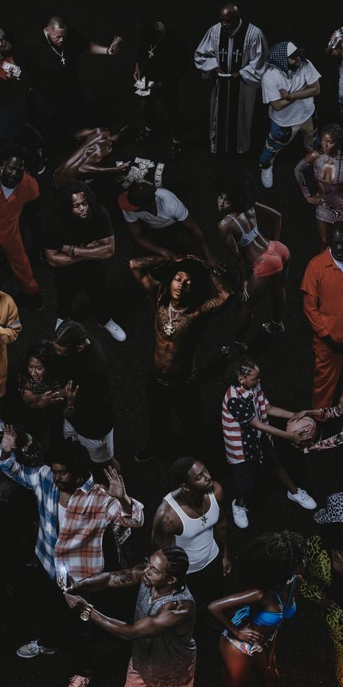 a group of people standing next to each other on a black ground with their hands in the air