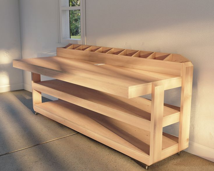 a wooden bench sitting next to a window in a white walled room with concrete flooring