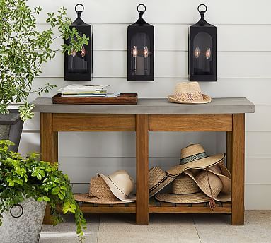 a table with hats on it in front of two lanterns and a potted plant