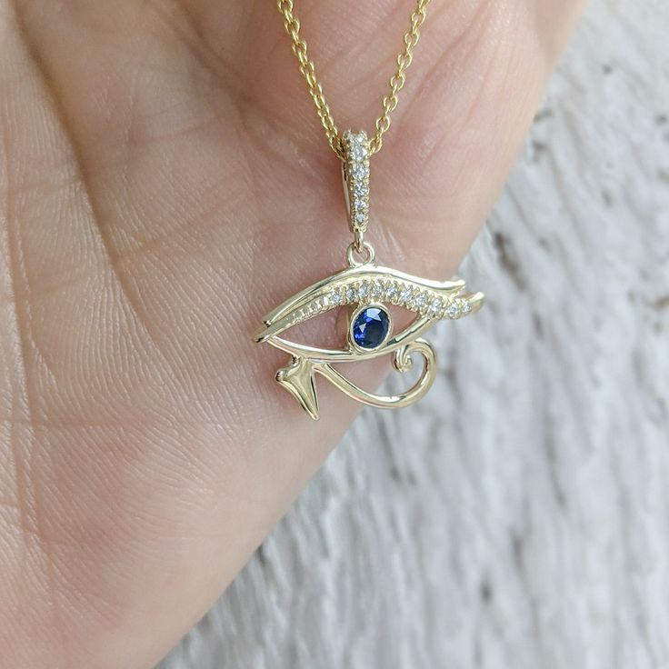 A diamond encrusted Eye of Horus (Wadjet) pendant with a faceted blue sapphire center stone for added color and beauty. It's just one of the many spiritual symbols we have available in our shop. Available in 14k and 18k yellow rose and white gold, as well as platinum--just choose your desired metal from the drop-down menu! This necklace is fully customizable. Prefer different dimensions? Prefer colored gemstones in place of diamonds? A different ancient Egyptian symbol? Contact us today for a no Yellow Gold Jewelry With Diamond Eyes For Anniversary, Symbolic Gemstone Jewelry For Formal Occasions, Gold Sapphire Jewelry With Diamond Cut, Gift Sapphire Jewelry With Diamond Cut, Sapphire Necklace With Diamond Cut As Gift, Sapphire Birthstone Gold Plated Jewelry, Symbolic Formal Jewelry With Diamond Accents, Formal Yellow Gold Jewelry With Diamond Eyes, Symbolic Diamond Jewelry With Gemstones