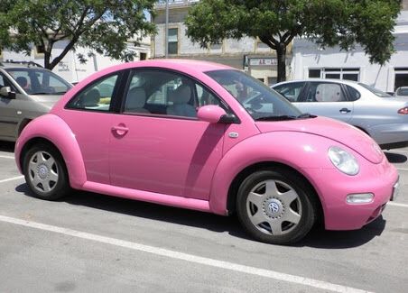 a pink car is parked in a parking lot