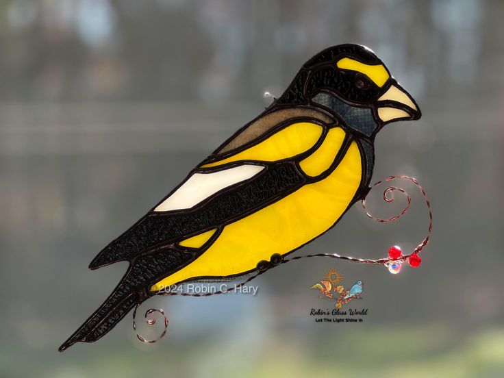 a yellow and black bird sitting on top of a window