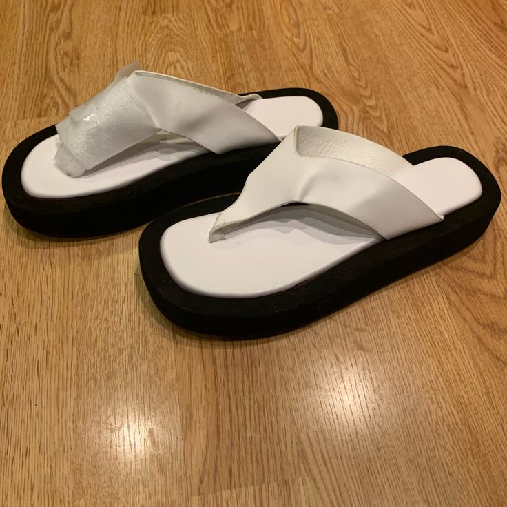 White Platform Thong Sandals With Black Bottom. Never Worn White Toe Post Flip Flops For Summer, Trendy White Toe Post Sandals, White Synthetic Summer Flip Flops, White Synthetic Flip Flops For Beach Season, White Trendy Flip Flops For Vacation, Trendy White Flip Flops For Vacation, Trendy White Flip Flops For Summer, Adjustable White Flip Flops For Beach Season, Trendy White Open Toe Flip Flops