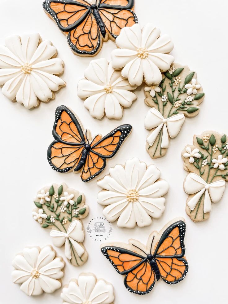 butterflies and flowers are arranged on a white surface