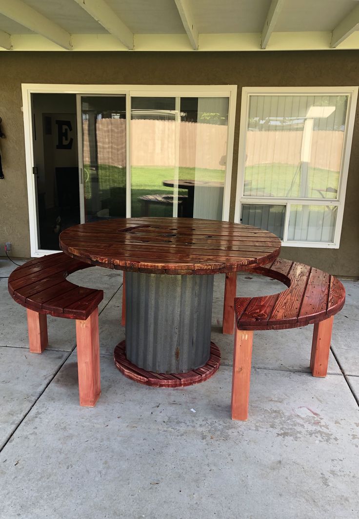 an outdoor table and bench made out of metal pipes with two benches on the side