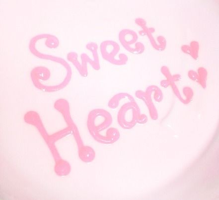 a white plate with pink frosting that says sweet heart