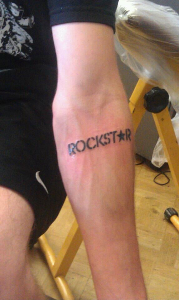 a man's arm with the word rockstar written on it in cursive font