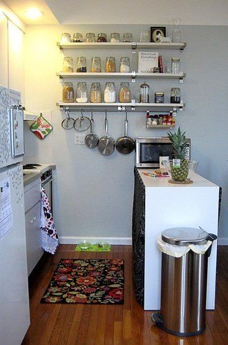 a small kitchen with stainless steel appliances and shelving