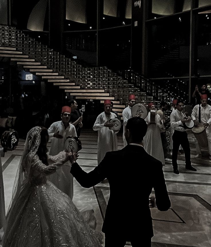 a bride and groom dancing in the middle of a dance floor with other people standing around