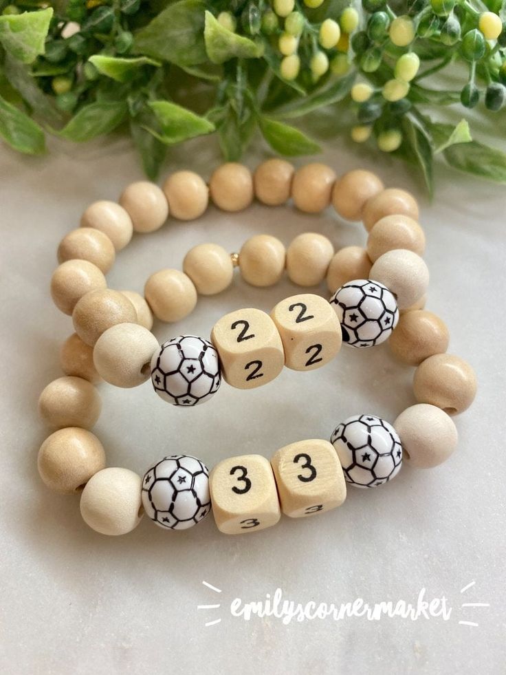 Soccer Bracelet // Soccer Mom Bracelet  Made with 10mm white and natural colored wooden beads   Personalize this bracelet with the name or number of your athlete!  ⚽️⚽️⚽️ Not only can you customize your bracelet with wooden numbers for your favorite player or with a name in black + white letter beads or gold + white letter beads ... Mix in a little color! Along with natural wooden beads, I also have black wooden, white wooden, red wooden, blue wooden and recently added kelly green wooden 10mm beads that can be added to these bracelets!   BRACELET SIZING TIPS 🤍 A good rule of thumb in order to get the right, comfortable size would be to measure around the widest part of your wrist and add a half inch for comfort. *Please note: If you find that your requested size isn't the right fit, you c Soccer Bracelet, Mom Bracelet, Wooden Numbers, Moms Bracelet, Soccer Mom, Letter Beads, Bracelets Handmade Beaded, White Letters, Kelly Green