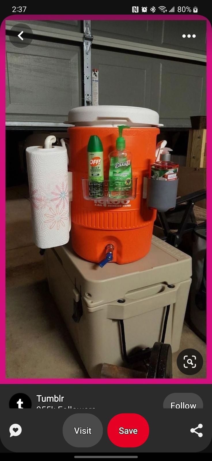 an orange cooler sitting on top of a cart