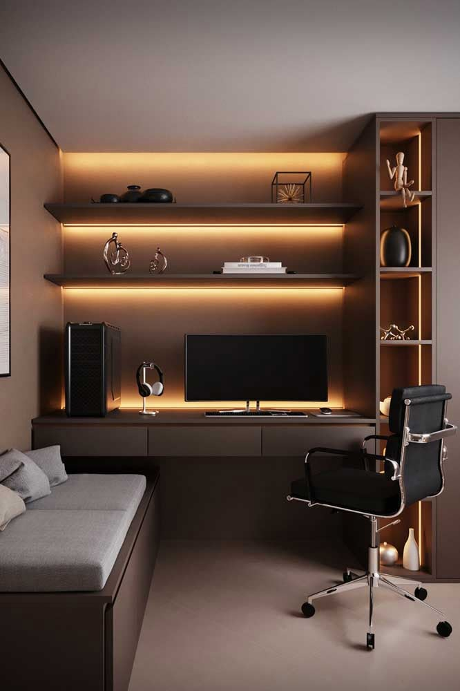 a modern home office with built - in shelving units and lighting on the wall